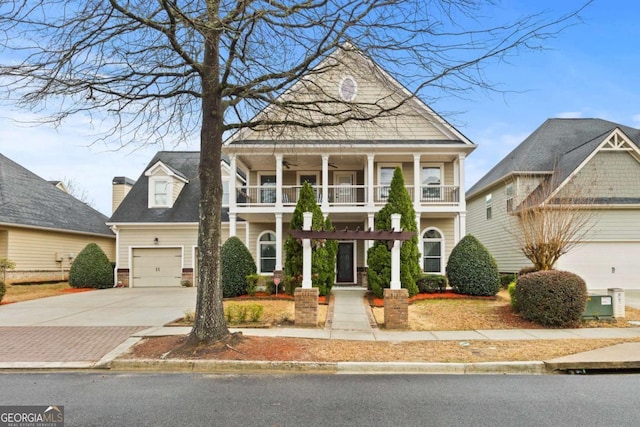 greek revival inspired property featuring ceiling fan, a garage, a balcony, and concrete driveway