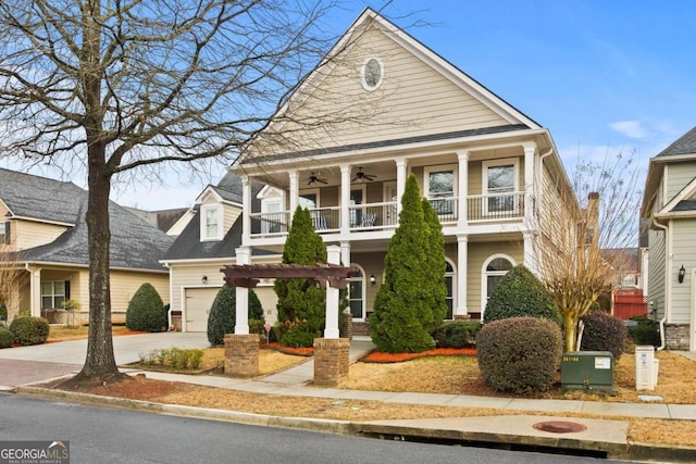 view of front facade featuring ceiling fan, a garage, a balcony, and concrete driveway