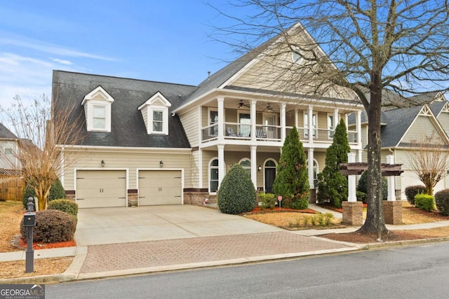 view of front of property featuring a balcony, roof with shingles, ceiling fan, concrete driveway, and a garage