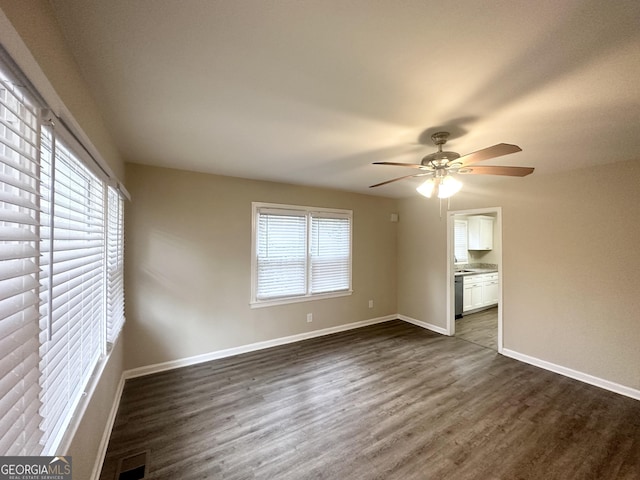 unfurnished bedroom with a ceiling fan, baseboards, visible vents, dark wood finished floors, and ensuite bathroom