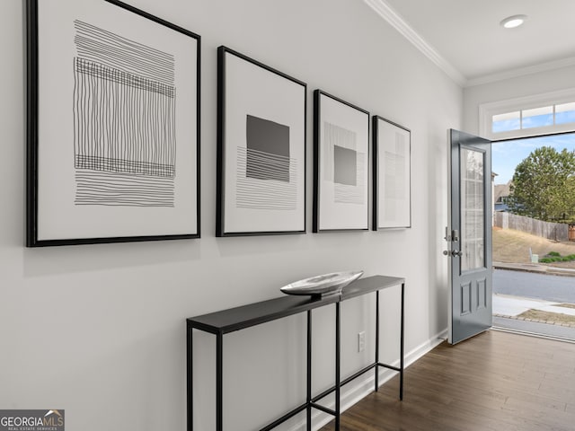 entryway with wood finished floors, baseboards, and ornamental molding