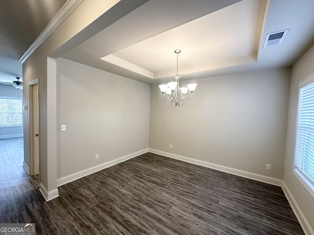 unfurnished room with a tray ceiling, dark wood-style floors, visible vents, and baseboards
