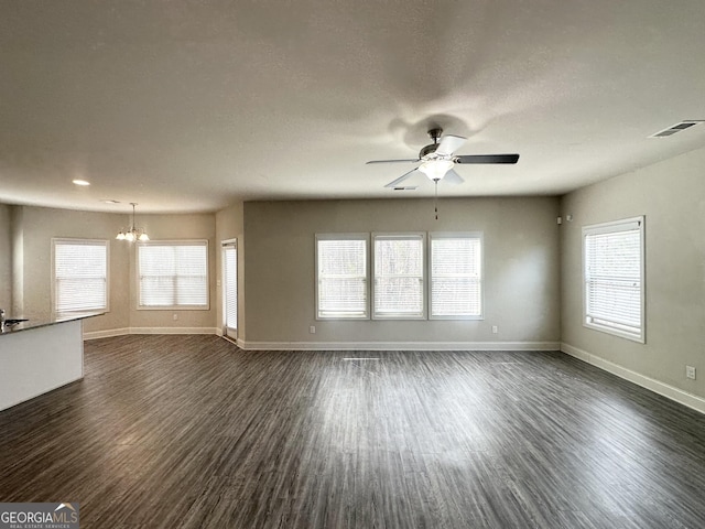 unfurnished living room featuring dark wood finished floors, plenty of natural light, and visible vents