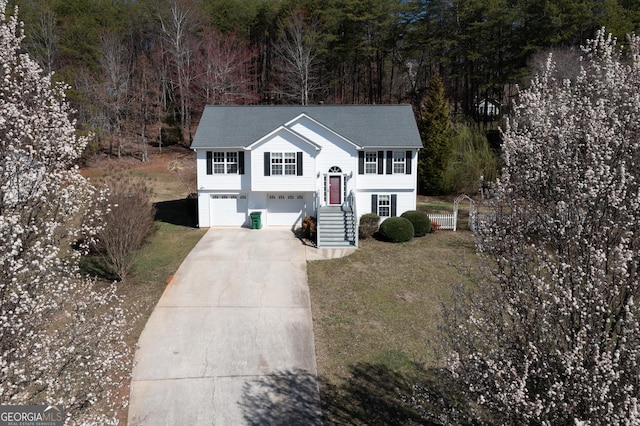 bi-level home with concrete driveway and a garage