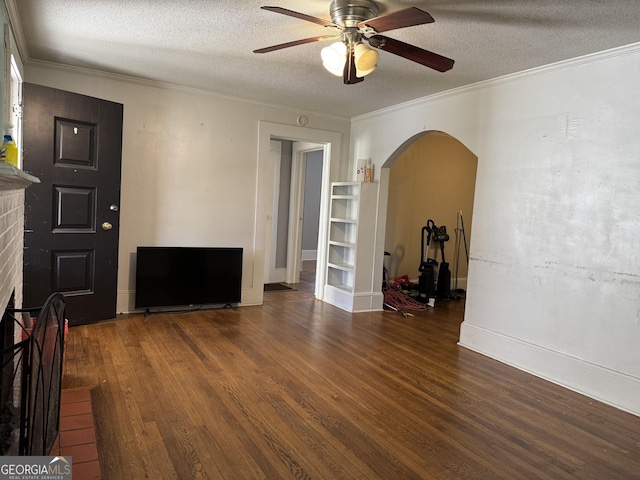 living area with wood finished floors, arched walkways, ceiling fan, a textured ceiling, and crown molding