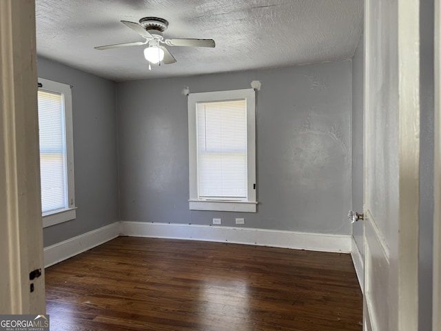 unfurnished room featuring baseboards, plenty of natural light, a textured ceiling, and wood finished floors