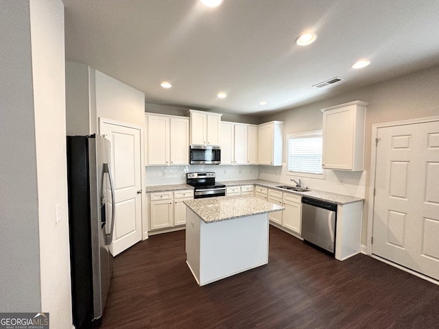 kitchen with a sink, visible vents, appliances with stainless steel finishes, and dark wood finished floors