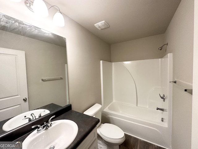 full bath with vanity, bathing tub / shower combination, toilet, and wood finished floors