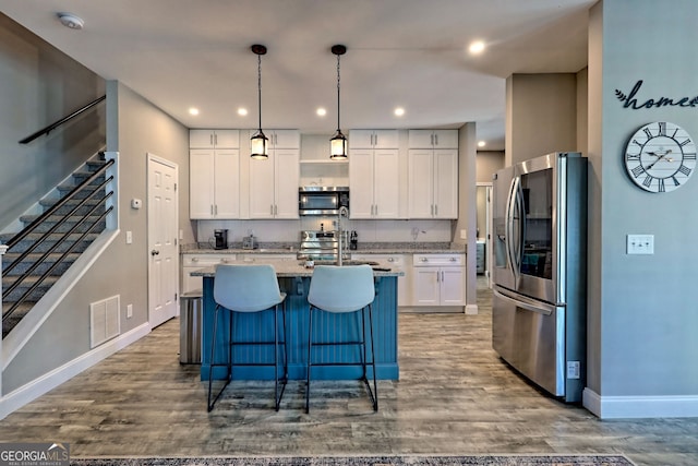 kitchen featuring visible vents, appliances with stainless steel finishes, wood finished floors, and white cabinets