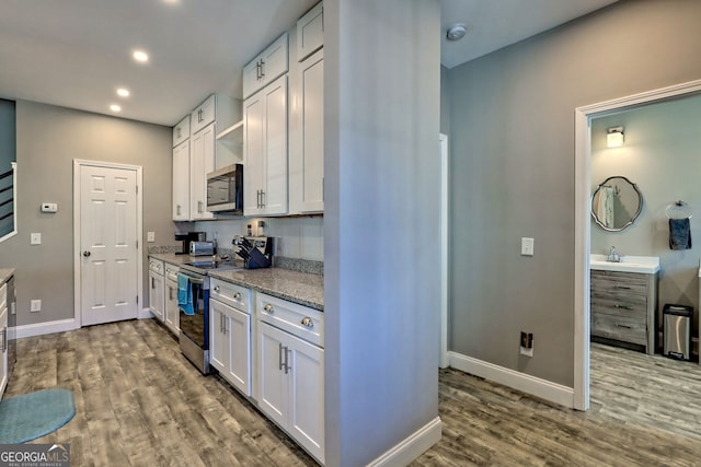 kitchen featuring white cabinetry, stainless steel appliances, dark wood-type flooring, and open shelves