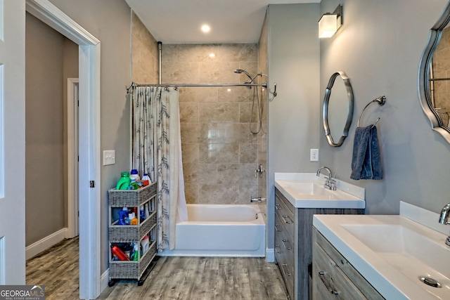 full bath featuring a sink, wood finished floors, and shower / tub combo