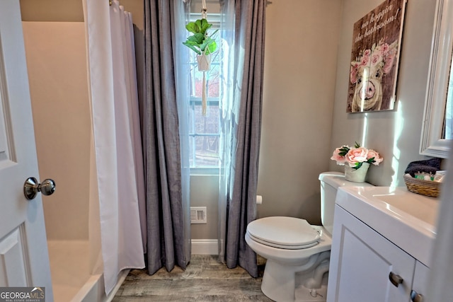 bathroom with vanity, toilet, a shower with shower curtain, and wood finished floors