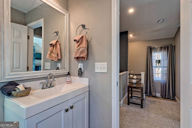 bathroom featuring vanity, recessed lighting, and baseboards