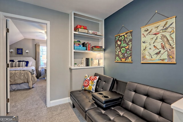 living area featuring vaulted ceiling, carpet flooring, and baseboards