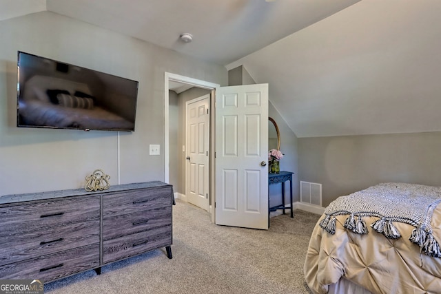 bedroom featuring baseboards, visible vents, light carpet, and lofted ceiling