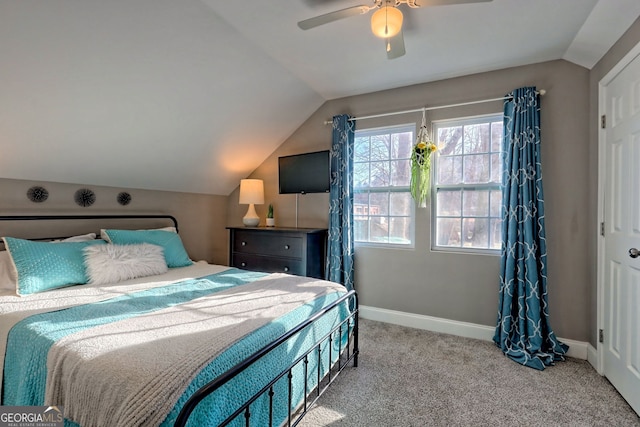 carpeted bedroom featuring lofted ceiling, baseboards, and ceiling fan