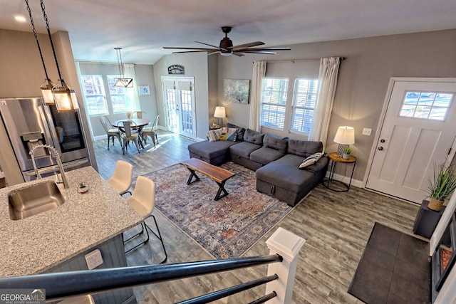 living room with a ceiling fan, wood finished floors, and baseboards