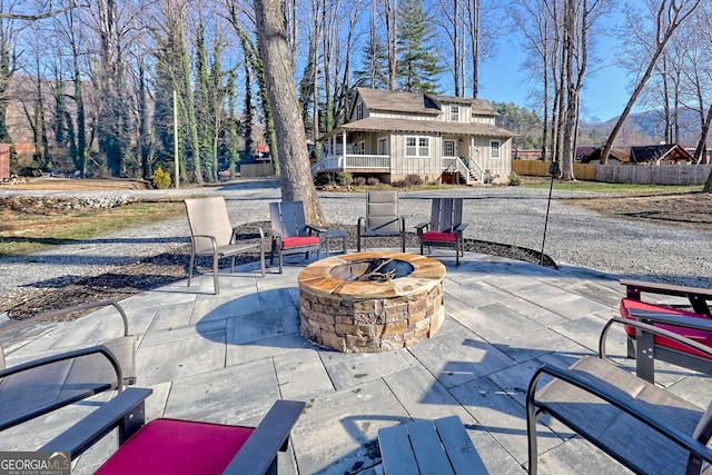 view of patio featuring an outdoor fire pit and fence