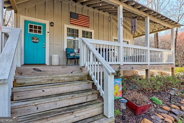 doorway to property with covered porch and board and batten siding