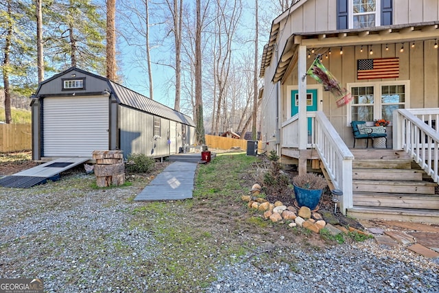 view of yard featuring an outbuilding, fence, and a detached garage