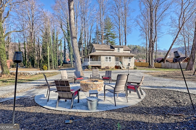 view of patio with an outdoor fire pit and fence