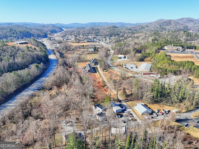 aerial view featuring a wooded view and a mountain view