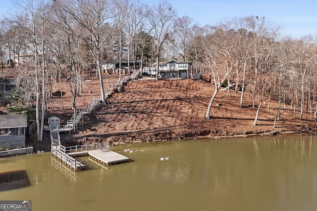 dock area featuring stairway and a water view