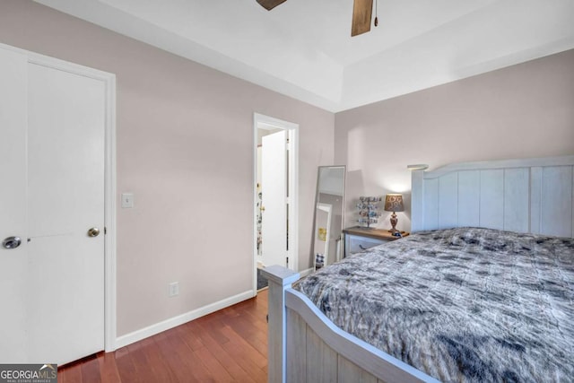 bedroom featuring dark wood-type flooring, a ceiling fan, and baseboards