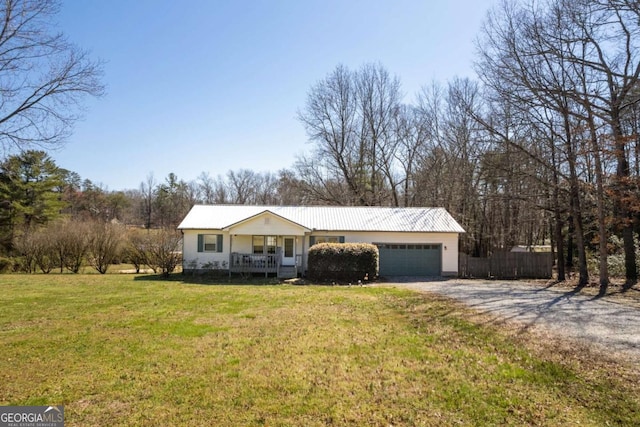 single story home featuring metal roof, a front yard, covered porch, and driveway