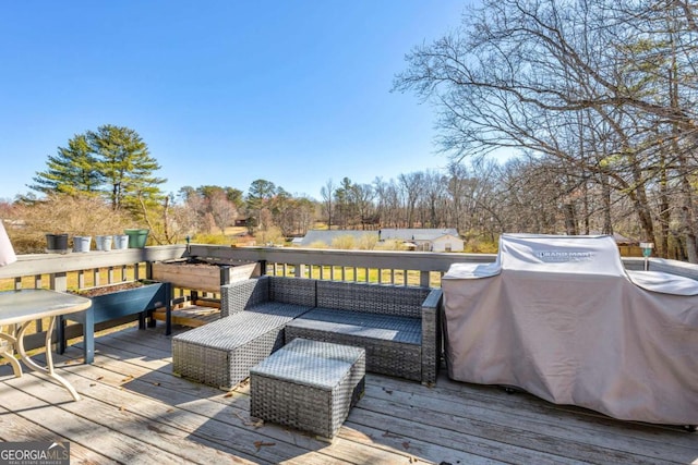 wooden terrace with a grill and outdoor lounge area