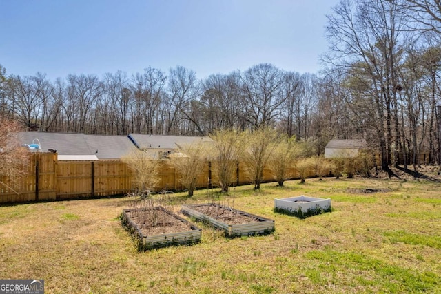 view of yard featuring fence and a garden