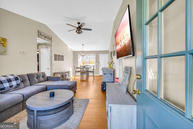 living room with lofted ceiling, light wood-style flooring, and a ceiling fan