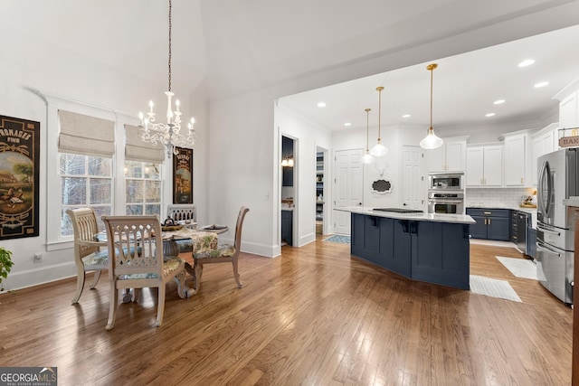 dining area featuring baseboards, recessed lighting, ornamental molding, light wood-style floors, and a notable chandelier