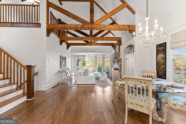 dining area with stairs, a notable chandelier, wood finished floors, and plenty of natural light