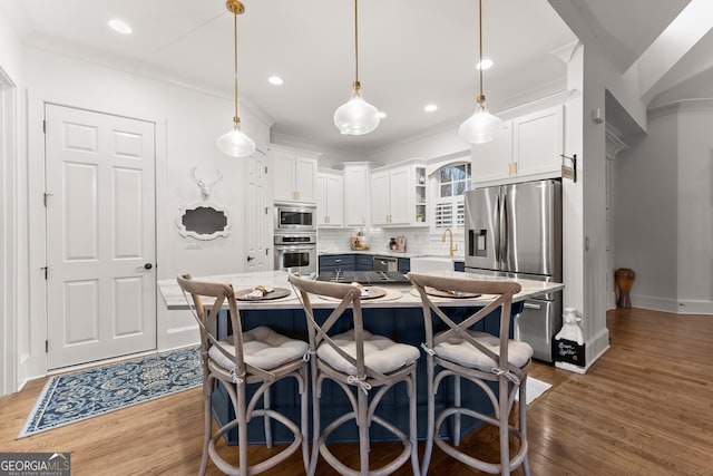 kitchen featuring decorative backsplash, appliances with stainless steel finishes, crown molding, and a sink