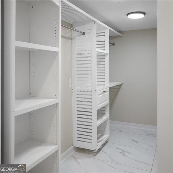 spacious closet featuring marble finish floor