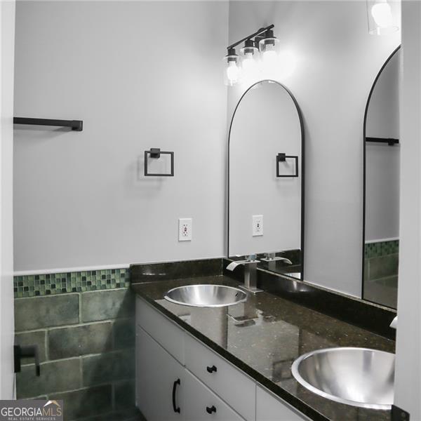 bathroom featuring double vanity, tile walls, and a sink