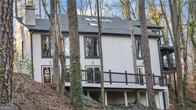 rear view of property with a wooden deck and a chimney