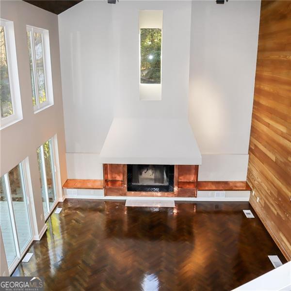 unfurnished living room featuring wooden walls and a tile fireplace