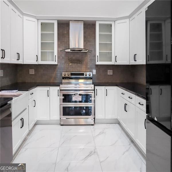 kitchen with wall chimney range hood, tasteful backsplash, double oven range, and marble finish floor