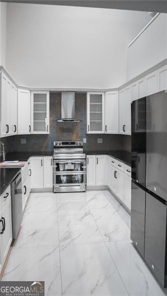 kitchen with marble finish floor, a sink, backsplash, stainless steel appliances, and wall chimney exhaust hood