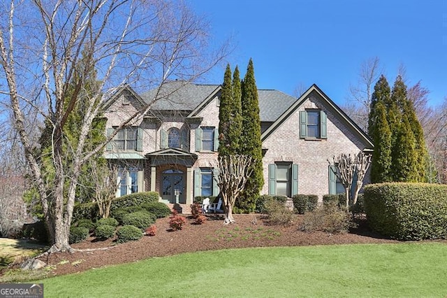 view of front of property with a front lawn and brick siding