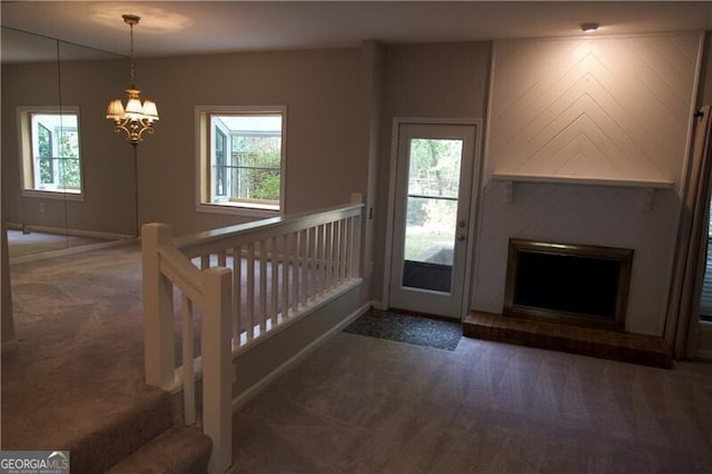 interior space featuring plenty of natural light, carpet flooring, and an inviting chandelier