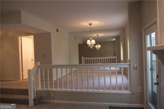 interior space with a chandelier, visible vents, carpet, and baseboards