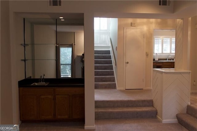 stairway with visible vents and wet bar