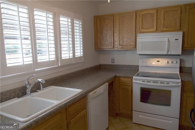 kitchen with white appliances, a healthy amount of sunlight, and a sink