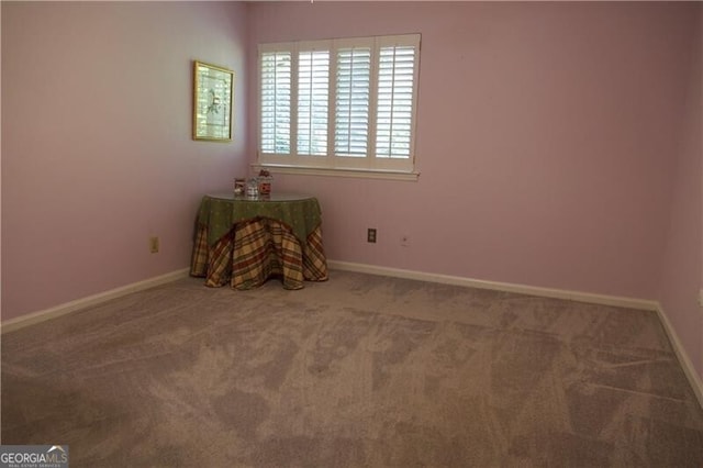 carpeted empty room featuring baseboards