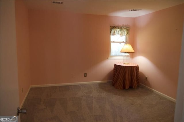 spare room with carpet, visible vents, and baseboards