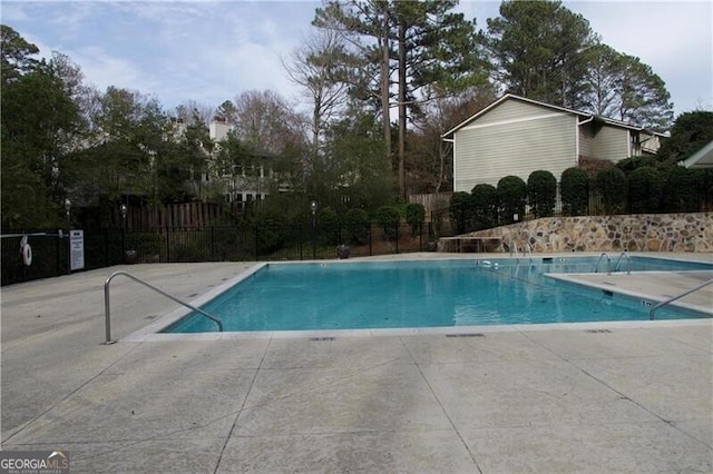 community pool featuring a patio and fence