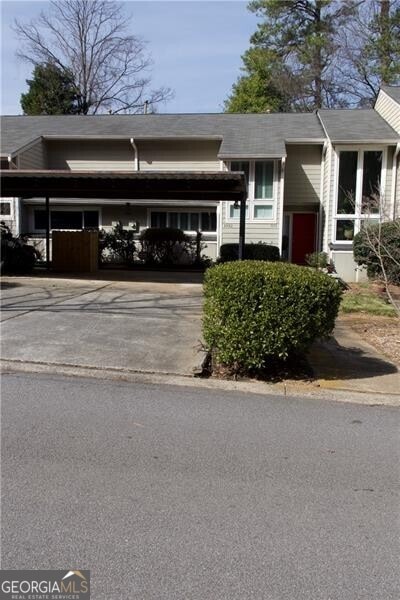 view of property with an attached carport and concrete driveway